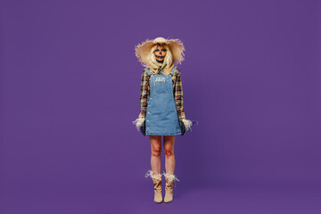 Full body blonde young woman 20s with Halloween makeup mask wearing straw hat scarecrow costume look camera isolated on plain dark purple background studio portrait Celebration holiday party concept.