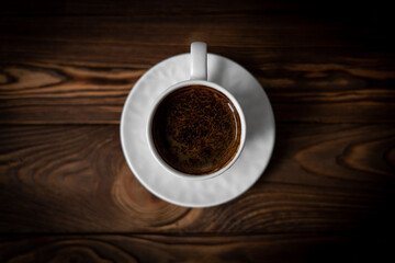 Top view of cup of coffe on the brown wooden table. Close-up