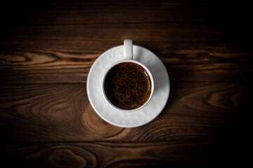 Top view of cup of coffe on the brown wooden table