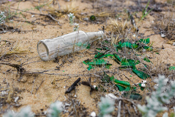 broken glass and bottle on the sandy shore