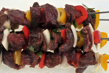 Brochettes de viande de boeuf avec des morceaux de poivrons et d'oignons avant cuisson en gros plan
