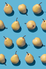 Pattern with yellow pears on blue background. Top view, flat lay.