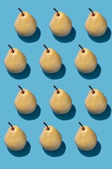 Pattern with yellow pears on blue background. Top view, flat lay.