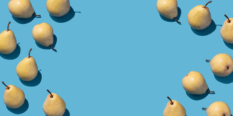 Pattern with yellow pears on blue background. Top view, flat lay, copy space.