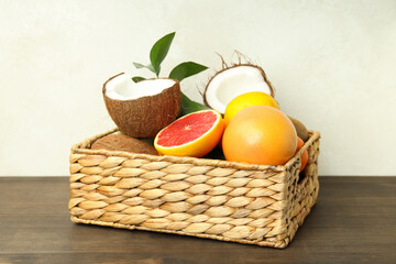 Basket with exotic fruits on wooden table