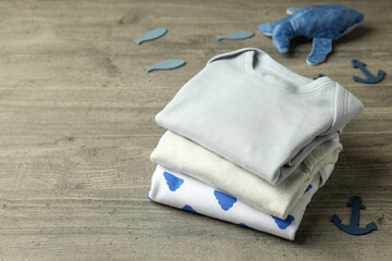 Concept of cute baby clothes on gray textured background