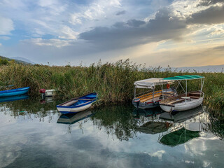 beautiful interesting boats in the reeds on the lake, evening colorful sky, reflection on the water