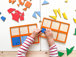 The child collects puzzles. Educational wooden toy for learning. Montessori materials. Fine motor skills, hand-eye coordination. Children's leisure, nursery.The concept of early development. squares. 