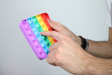 Hands playing with pop it, bubble fidget sensory toy 