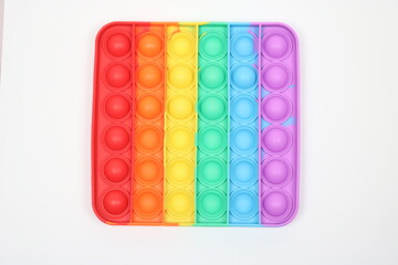 Square rainbow pop it fidget toy. Anti-stress push bubble. 