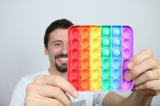 Adult man is playing with stress relief bubble toy pop it 