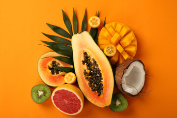 Fototapeta na wymiar Exotic fruits set on orange background, top view