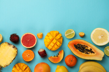 Exotic fruits set on blue background, space for text