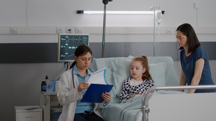 Obraz premium Sick patient wearing oxygen nasal tube resting in bed recovering after sickness medical surgery during recovery consultation. Pediatrician woman doctor discussing disease expertise in hospital ward