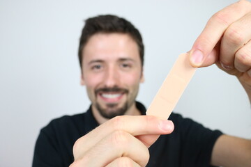 Young man showing adhesive bandage plaster 