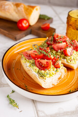 Breakfast with vegetarian sandwiches with avocado and tomatoes on a big orange plate