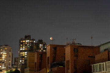 city at night with lunar eclipse