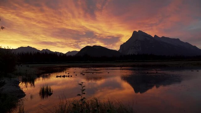 Sunrise in Banff over Vermillion Lake with the sky on fire and ducks on the lake