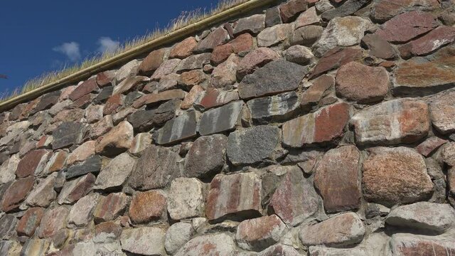 A panning view of a colorful and interesting old stone-made wall of an old and ancient fortress korela now a museum in Russia.