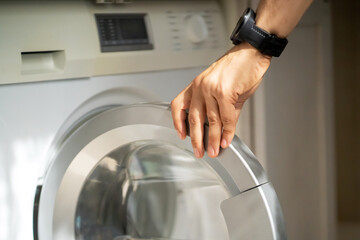 Man is using the modern washing mashine.