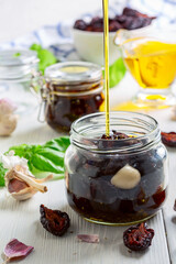 Preparation of dried plums with Italian herbs and olive oil.