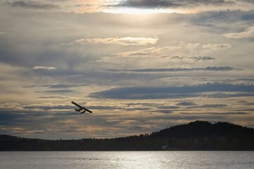 A small white seaplane takes off from Lake Storsjön in Östersund - 460256393