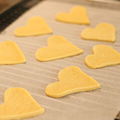 Heart-shaped puff pastry on baking paper. Homemade cookies for the holiday. Dessert for the family