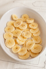sliced banana in a glass bowl isolated on white