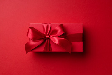Top view on red gift box on red background for Christmas or Valentine's day.