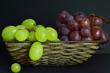Grape variety, clusters in wicker basket and dark background.