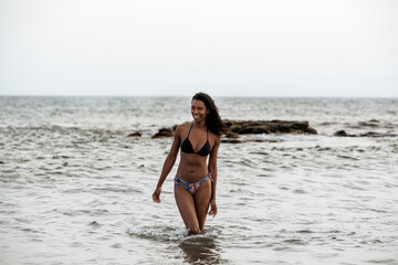 Woman in bikini in a volcanic beach
