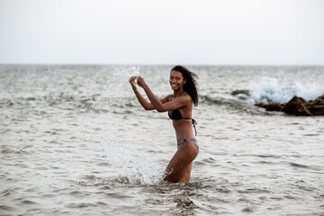 Fototapeta na wymiar Woman in bikini in a volcanic beach