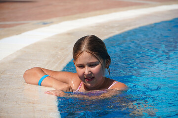  Little girl at swimming pool. Smiling Girl having fun in swimming pool on summer vacation....