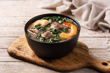 Beef, okra stew and spinach soup in bowl on wooden table