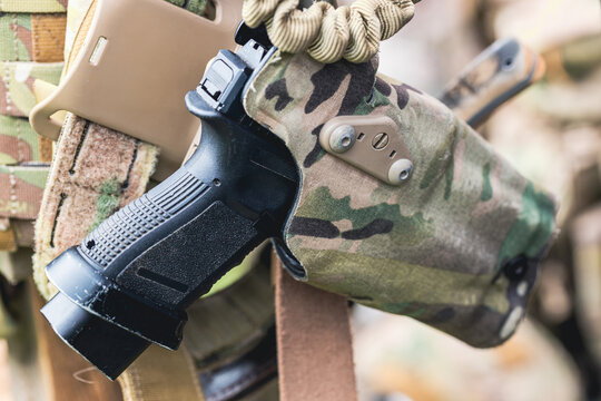A pistol protruding from a soldier's holster