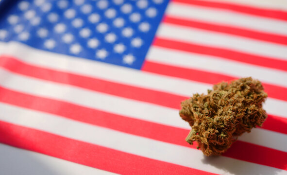Cannabis bud lay on American flag. Medical marijuana legalization. Recreational drugs law