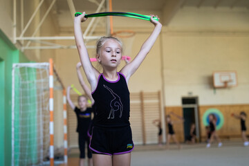 Portrait of girl gymnast doing exercise with rope on training in gym