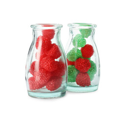 Fototapeta na wymiar Delicious gummy raspberry candies in glass bottles on white background
