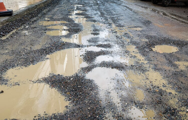 rainwater puddles on the old asphalt road