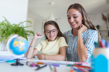 Little girl coloring picture in album during staying at home with mother, widescreen. Generation and happy family concept