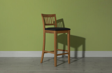 Stylish bar stool near light green wall indoors