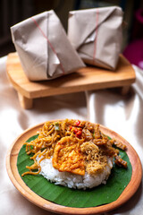 Nasi Campur, Indonesian Typical Food from East Java Province. Contain white rice, spicy tofu, tempeh, serundeng, and fried noodles