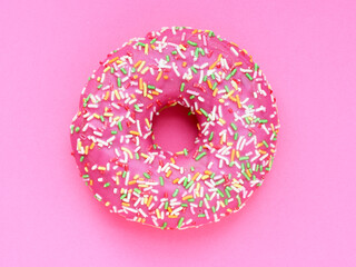 Donut with a pink icing on a pink background - obrazy, fototapety, plakaty