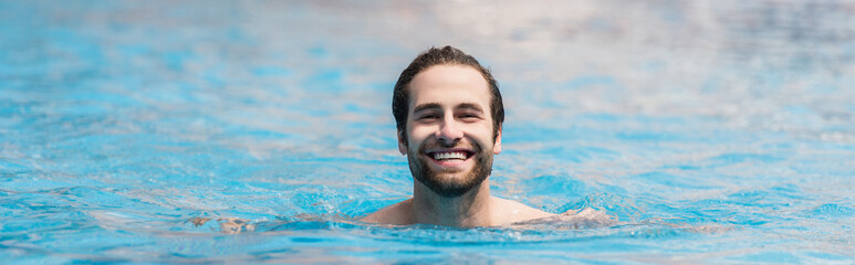 Cheerful man swimming in outdoor pool, banner