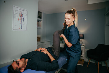 Caucasian female physiotherapist assisting injured patient with rehabilitation exercises