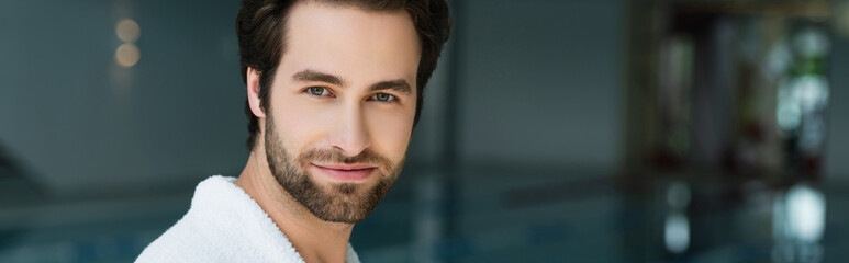 Obraz premium Man in bathrobe looking at camera in spa center, banner