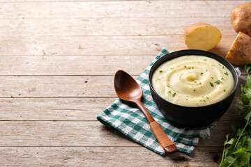 Mashed potatoes in a bowl on wooden table.  Copy space