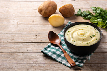 Mashed potatoes in a bowl on wooden table.  Copy space