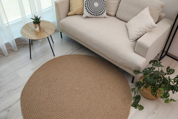 Living room interior with comfortable sofa and stylish round rug, above view