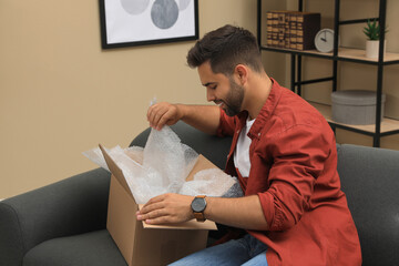 Man unpacking parcel at home. Online shopping